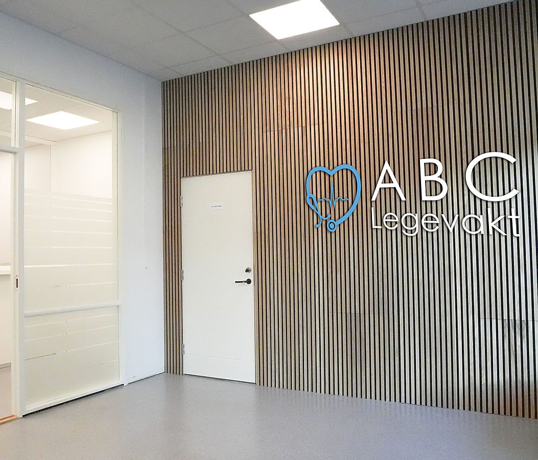 Korridor inn til ABC-klinikken på Jessheim, med trevegg og logo.